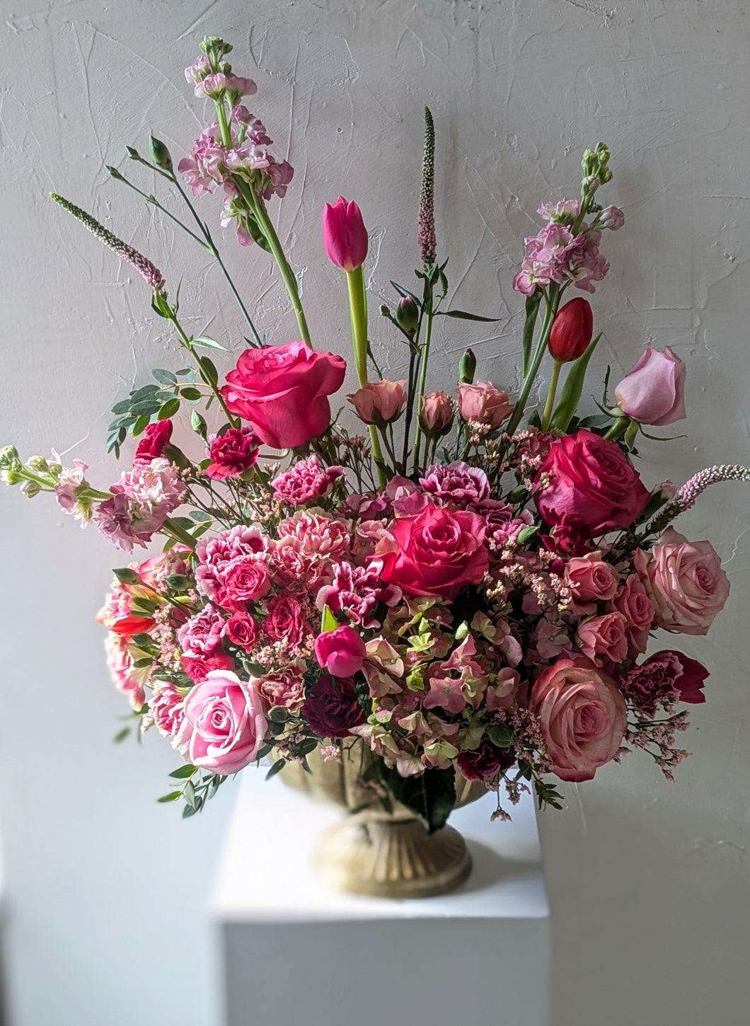 Lavish floral arrangement in gold compote vase
