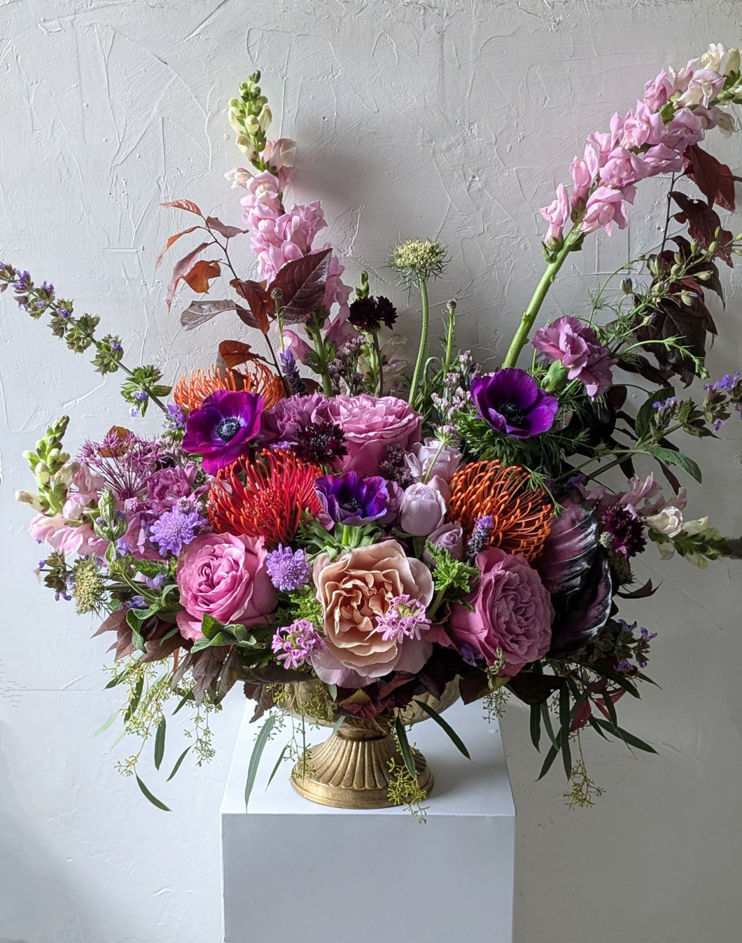 Lavish floral arrangement in gold compote vase