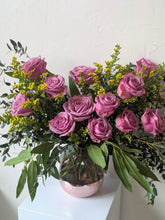 Load image into Gallery viewer, Bella Rose bouquet features 12 beautiful roses, lush greenery and filler. Displayed in a pretty clear and pink glass vase. Available for local delivery. 
